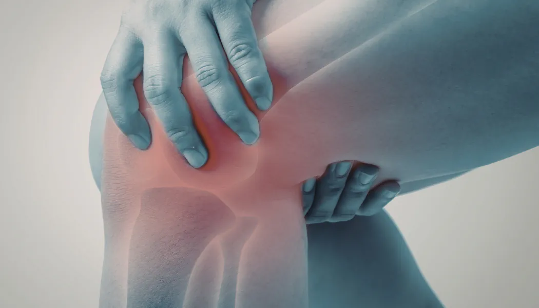 personne qui se tient le genou de douleur